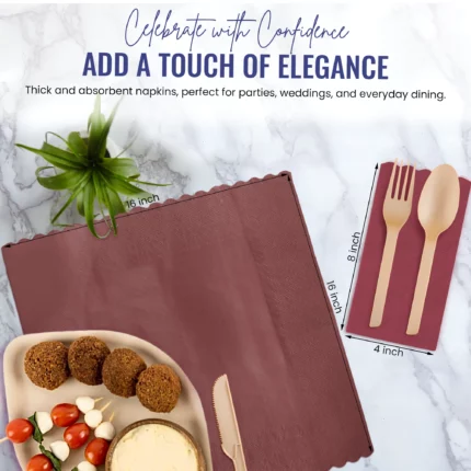 Burgundy napkin with beige utensils on marble, paired with appetizers, creating a sophisticated and celebratory dining experience.
